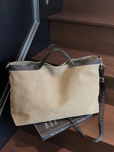 Large khaki canvas tote bag with brown trim and stripe lining on wooden steps