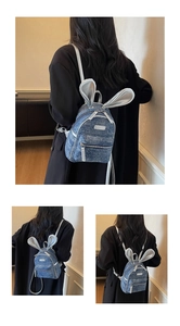Detail of mini denim backpack with silver rabbit ears and polished metal zippers