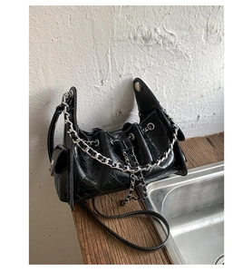 Détail du sac matelassé noir avec finition brillante et accents de chaîne argentée