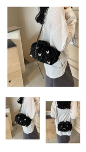Macro detail of black pleated cloud bag featuring delicate white butterfly appliqués and chain