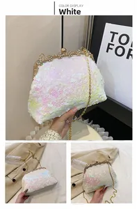 Detail van witte pailletten avondtas met gouden bloemsluiting en afneembare ketting