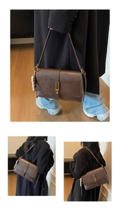 Gros plan du sac bandoulière rétro marron foncé avec boucle dorée et breloque perlée