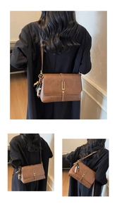 Détail d'un sac bandoulière marron rétro avec boucle dorée et pampille à perles tricolores