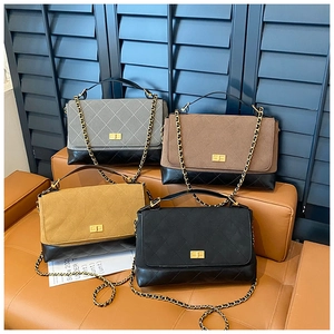 Detail of four quilted suede flap bags with chain straps in grey, brown, and black colors