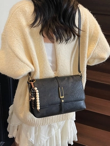 Sac bandoulière vintage noir avec texture en cuir plissé et breloque perlée décorative