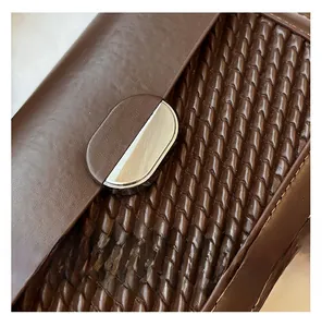 Close-up of brown woven leather texture with semi-circular silver metal buckle