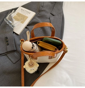 Detailed interior of a contrast color bucket bag with phone, umbrella, and card holder