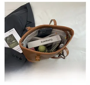 Interior of brown pebbled tote bag showing large capacity with phone and books inside