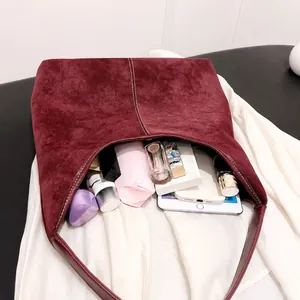 Vista interior del bolso tote de ante burdeos que muestra gran capacidad de almacenaje