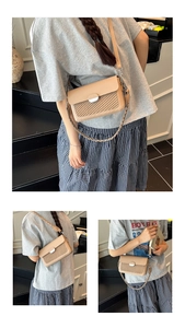 Detail of beige shoulder bag showing woven texture flap and silver oval metal buckle