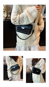 Detail of black woven shoulder bag with silver buckle and adjustable shoulder strap