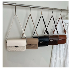 Close-up of stylish square crossbody bags with metal buckles and woven texture straps