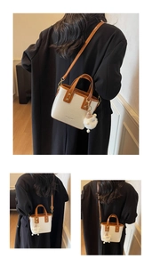 Detail view of cream and brown crossbody bucket bag with a cute white sheep charm
