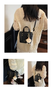 Detail of black glossy patent leather bucket bag with a cute white lamb plush charm