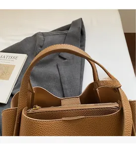 Detail of soft brown lychee grain leather bucket bag with top handle and inner zip pocket