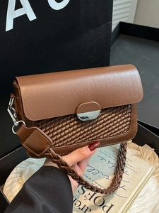 Brown leather underarm bag with woven texture and silver metal clasp in retro style