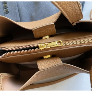 Vista ravvicinata dell'interno della borsa in pelle marrone con cerniera oro e chiusura magnetica