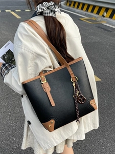 Black large capacity faux leather tote bag with brown trim and gold pendant detail