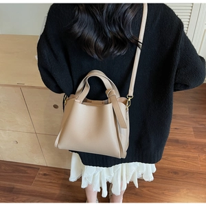 Vista posteriore dettagliata della borsa a secchiello beige con trama a grana fine
