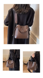 Detail of brown litchi pattern leather bucket bag with wide canvas strap and bottom corners