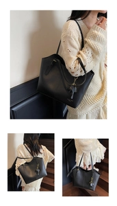 Detail of black leather tote bag with Fashion trend WWTU lettering and elephant charm