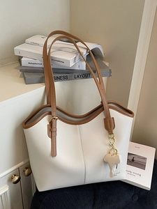 Minimalist ivory tote bag with brown trim, adjustable strap and elephant pendant charm