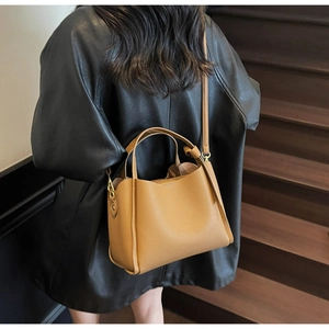 Borsa a secchiello in pelle marrone con grana litchi portata a tracolla