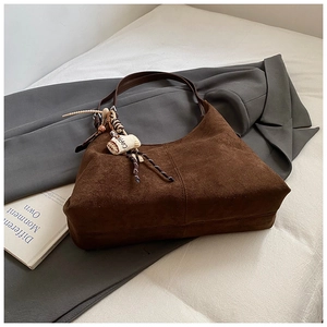 Close-up of vintage brown suede tote bag featuring a coffee charm and vertical stitching