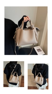 Dettaglio borsa tote beige con trama litchi, manico a nodo e tracolla regolabile
