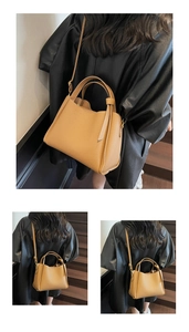 Dettaglio borsa in pelle grana color cammello con manici tondi e tracolla