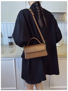 Sac à main vintage marron avec poignée et bandoulière montrée sur un modèle