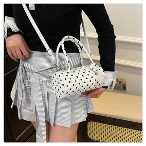 Vue détaillée du sac cylindrique à pois blancs avec boucles argentées et perle