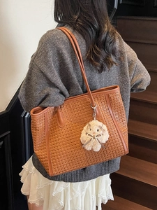 Brown woven tote bag with cute pearl bunny charm shown on model for a casual look