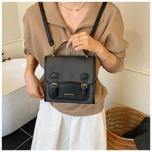 Detail of vintage gray and black contrast shoulder bag with golden buckle straps and top handle