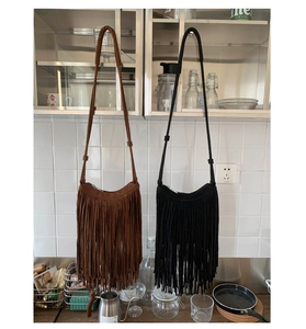 Detailed close-up of brown and black bohemian tassel shoulder bags with long fringe accents
