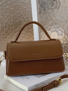Sac à main rétro marron en cuir texturé avec détails dorés sur fond artistique moderne