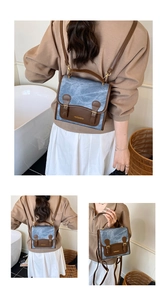 Detail view of vintage blue textured backpack with brown leather straps and gold buckles