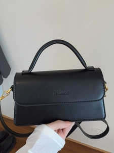 Sac à main vintage en cuir noir avec ferrures dorées et bandoulière réglable