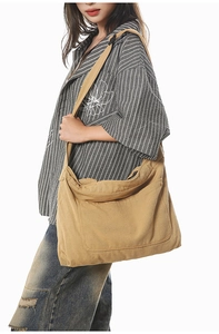 Side view of large khaki canvas crossbody bag showing spacious capacity and soft texture