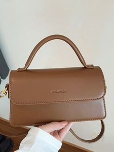 Sac à main minimaliste en cuir marron caramel avec poignée et logo en relief