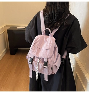 Vista trasera de una modelo con mochila de nailon morado claro y cierre de cordón