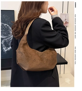 Close-up of brown suede hobo bag styled with a black blazer for a chic commuting look