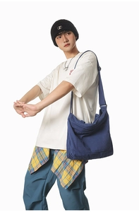 Detail of dark blue canvas messenger bag with adjustable strap and front pocket