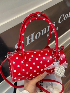 Sac cylindre rouge à pois en cuir verni avec breloque cœur perle et bandoulière amovible