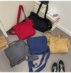 Detail of multi-color canvas tote bags showing coarse texture and versatile straps