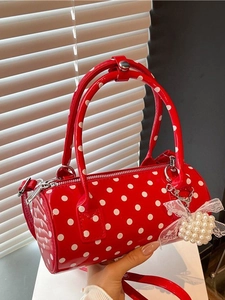 Sac à main cylindrique rouge à pois avec breloque perle et bandoulière fine