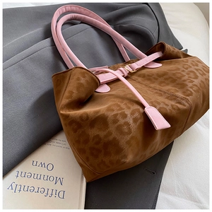 Detail of leopard print tote with pink handles and golden metal buckle decoration
