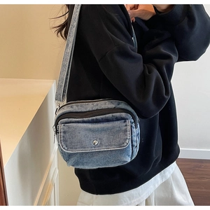 Blue denim crossbody bag with silver snap pocket and wide shoulder strap on model