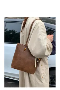Brown vintage oil wax leather tote bag with stylish beaded charm and shoulder strap