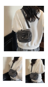 Detail of washed denim shoulder bag with adjustable metal buckle and front flap pocket